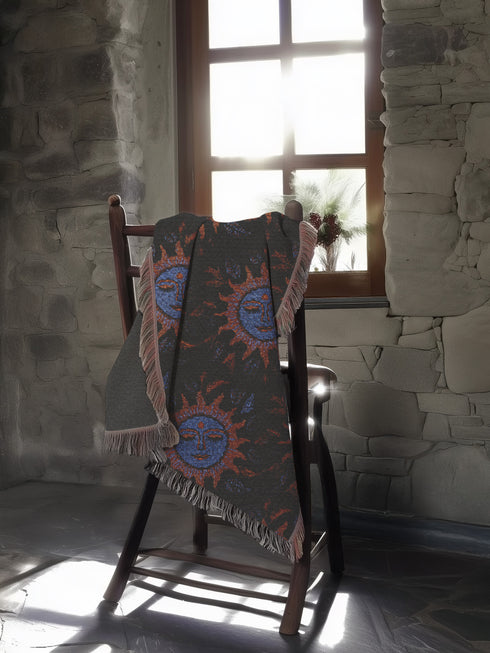 Luxurious woven cotton throw blanket featuring mystical blue sun faces with copper rays on black background, bordered by elegant fringe. Perfect celestial wall hanging, witchy bedroom decor, or dark academia throw for couch or bed.